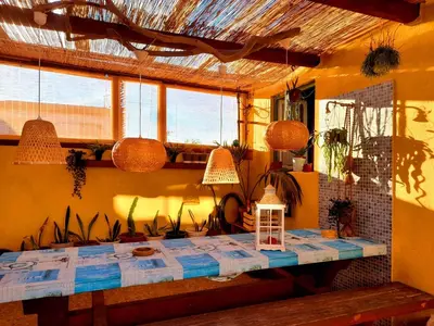 a dining room with a table and some windows at Casa Mestre Guesthouse in Vila do Bispo