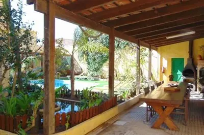 a porch of a house with a pool and a table at Casa Mestre Guesthouse in Vila do Bispo