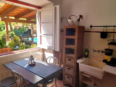 a dining room with a table and a sink and a window at Casa Mestre Guesthouse in Vila do Bispo