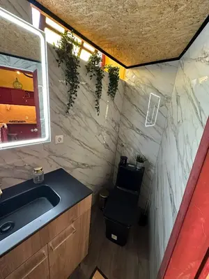 a bathroom with a sink and a toilet with plants at Casa Mestre Guesthouse in Vila do Bispo