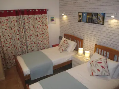 a bedroom with two beds and two candles in it at Casa Carmela in Burgau