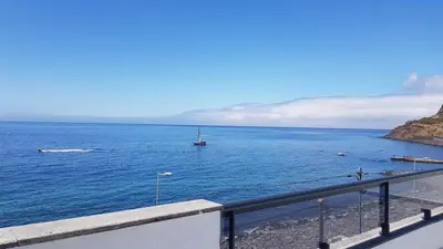 a view of the ocean with a boat in the water at Villa Sunset Avenue in Paul do Mar