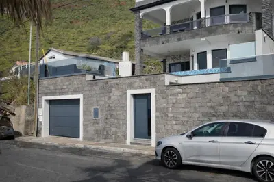 a white car parked in front of a building at Villa Sunset Avenue in Paul do Mar