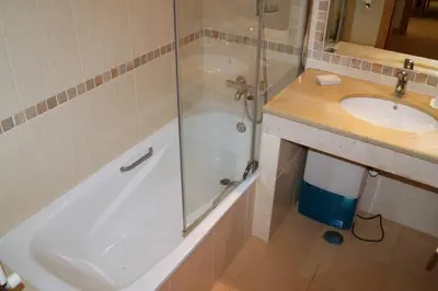 a bathroom with a shower and a tub and a sink at Vila das Acacias in Luz
