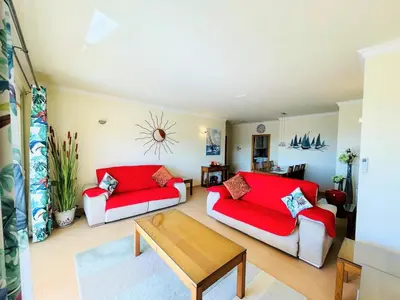 a living room with two red couches and a table at Vila das Acacias in Luz