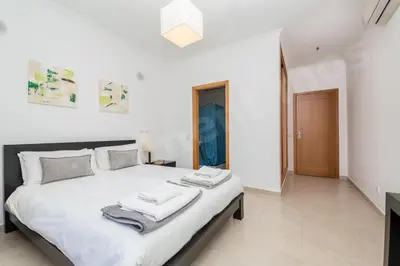 a bedroom with a large white bed with towels on it at Apartment Mos in Lagos