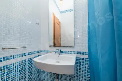 a blue tiled bathroom with a sink and a mirror at Apartment Mos in Lagos