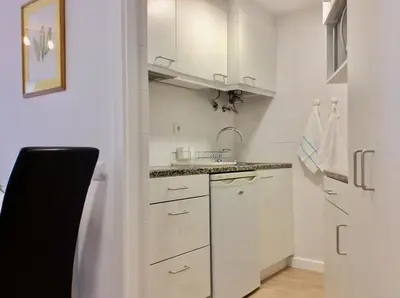 a kitchen with white cabinets and a sink at Cosy Studio at Lido with Pool in Funchal