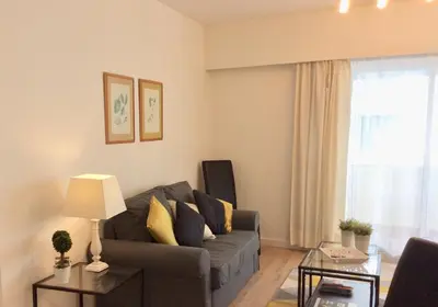 a living room with a couch and a window at Cosy Studio at Lido with Pool in Funchal