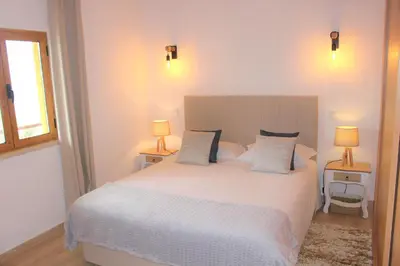 a bedroom with a large white bed with two lamps at Quinta das Alfambras in Aljezur
