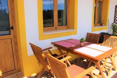 a dining room with a wooden table and chairs at Quinta das Alfambras in Aljezur