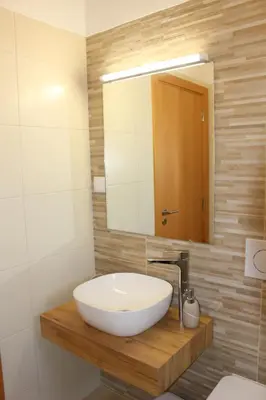 a bathroom with a white sink and a mirror at Quinta das Alfambras in Aljezur