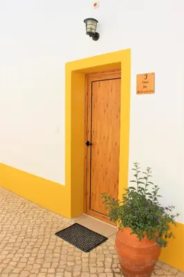 a door to a building with a potted plant at Quinta das Alfambras in Aljezur