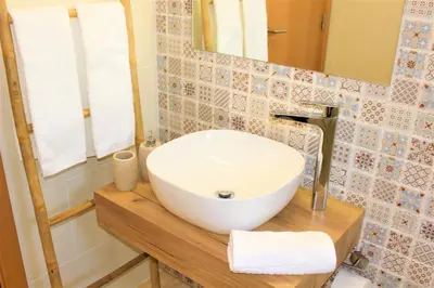a bathroom with a white sink and a mirror at Quinta das Alfambras in Aljezur
