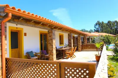 a house with a wooden fence and a patio at Quinta das Alfambras in Aljezur