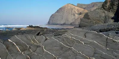 a group of rocks on a beach with the ocean at Casa Flora T1 - Vila do Bispo in Vila do Bispo