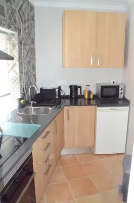 a small kitchen with a sink and a microwave at Casa Flora T1 - Vila do Bispo in Vila do Bispo