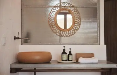 a mirror and two bottles of wine on a table at Hortas do Rio - Casa de Campo in Carrapateira