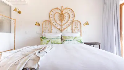a bedroom with a large white bed with a large heart headboard at Hortas do Rio - Casa de Campo in Carrapateira