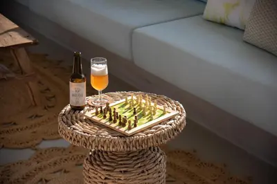 a table with a bottle and a glass of beer at Hortas do Rio - Casa de Campo in Carrapateira