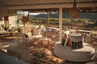 a patio with a couch and chairs and tables at Hortas do Rio - Casa de Campo in Carrapateira