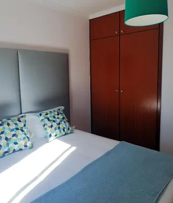 a bedroom with a bed with a green lamp at Funchal petrolhead apartment in Funchal