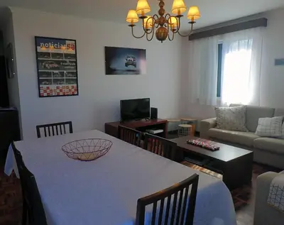 a living room with a table and a couch at Funchal petrolhead apartment in Funchal