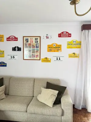 a living room with a couch and signs on the wall at Funchal petrolhead apartment in Funchal