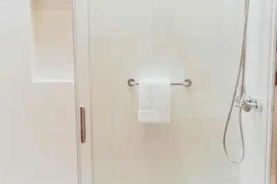 a shower with a towel hanging on a shower door at Apartamentos Ferreiros by Heart of Funchal in Funchal