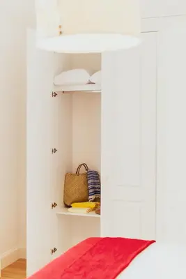 a white cabinet with a red rug in a room at Apartamentos Ferreiros by Heart of Funchal in Funchal