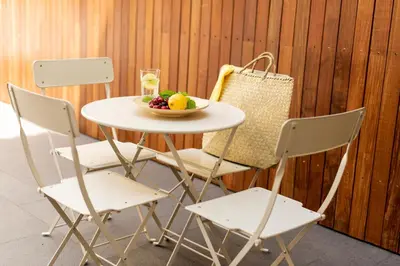 a table and chairs with a bowl of fruit and a purse at Apartamentos Ferreiros by Heart of Funchal in Funchal