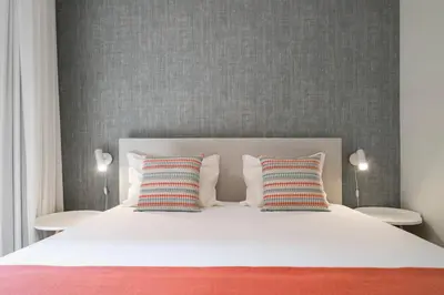 a bedroom with a white bed with two pillows at Reis Magos IV by An Island Apart in Caniço