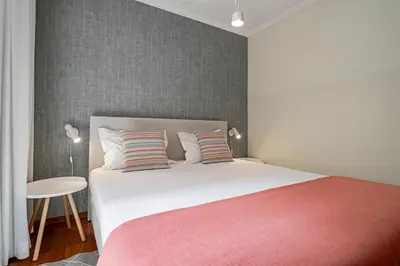 a bedroom with a large bed with a pink blanket at Reis Magos IV by An Island Apart in Caniço
