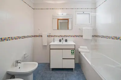 a white bathroom with a sink and a toilet and a tub at Reis Magos IV by An Island Apart in Caniço