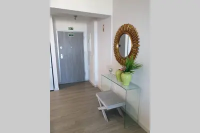 a mirror on a dresser in a hallway with a chair at Sarah House in Funchal