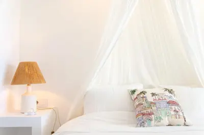 a white bed with a pillow and a lamp at Casa da Praia - Lagos in Lagos