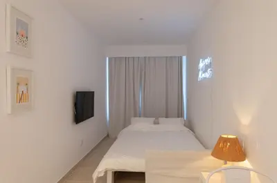 a hotel room with two beds and a tv at Casa da Praia - Lagos in Lagos