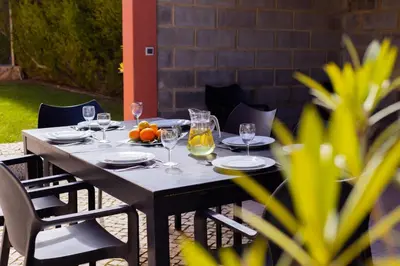 a wooden table with wine glasses and fruit on it at Villa Farol in Sagres