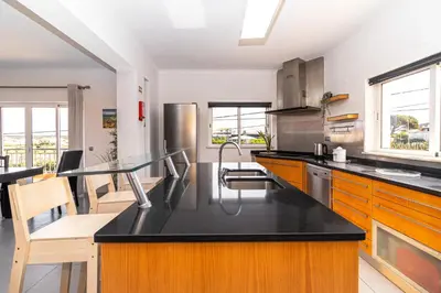 a kitchen with a black counter top and wooden cabinets at Villa Farol in Sagres