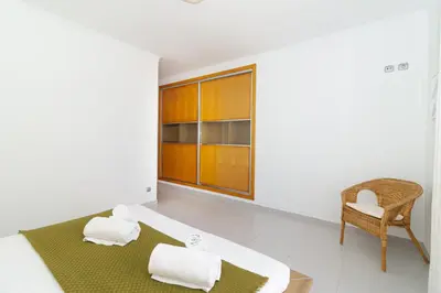 a bedroom with a bed and a chair at Villa Farol in Sagres