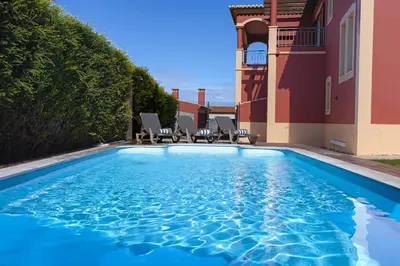 a swimming pool in front of a house at Villa Farol in Sagres