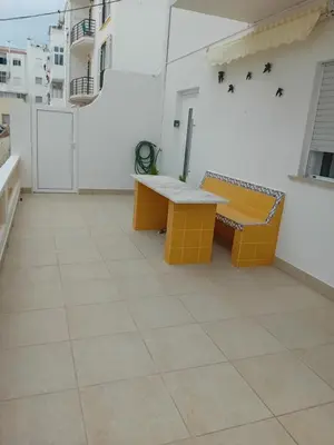a patio with a bench and a table on a building at Burgau Mar in Burgau