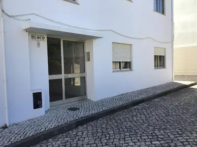 a white building with a door on the side at Burgau Mar in Burgau
