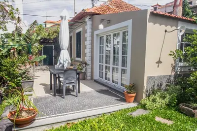 a small patio with a table and an umbrella at Casa da Bungavillia in Machico