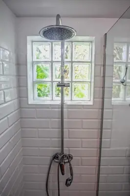a shower in a bathroom with a window at Casa da Bungavillia in Machico