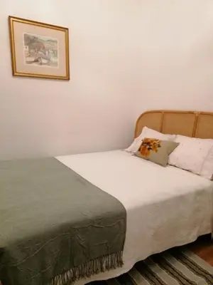 a bed in a bedroom with a picture on the wall at Casa da Bungavillia in Machico