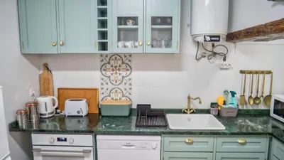 a kitchen with blue cabinets and a green counter top at Casa da Bungavillia in Machico