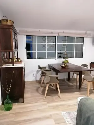 a dining room with a wooden table and chairs at Casa da Bungavillia in Machico