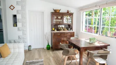 a dining room with a wooden table and chairs at Casa da Bungavillia in Machico