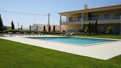 a swimming pool in a yard next to a building at Apartamento 7 Mares in Sagres